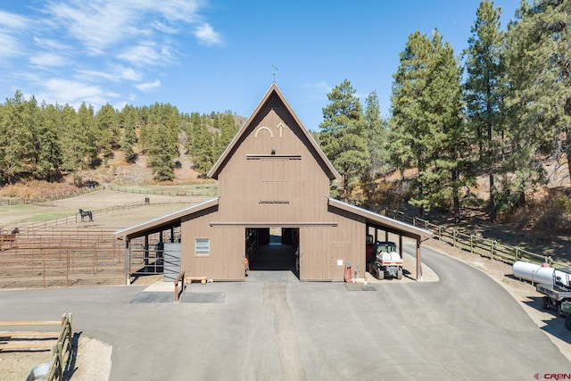 view of front of property with an exterior structure, a garage, a barn, and an outdoor structure