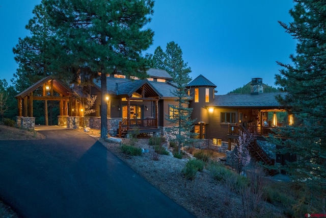 view of front of property featuring aphalt driveway and stone siding