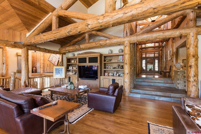 living area featuring beamed ceiling, wooden ceiling, wood finished floors, and stairs