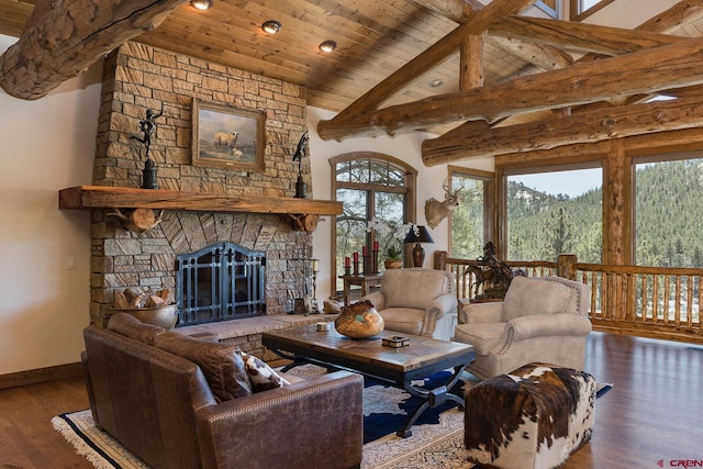 living room with beamed ceiling, wood ceiling, a stone fireplace, wood finished floors, and high vaulted ceiling