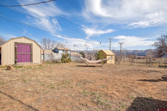 view of yard with a storage shed, fence, and an outdoor structure