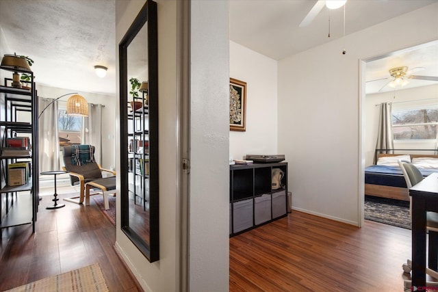 corridor featuring baseboards and wood finished floors