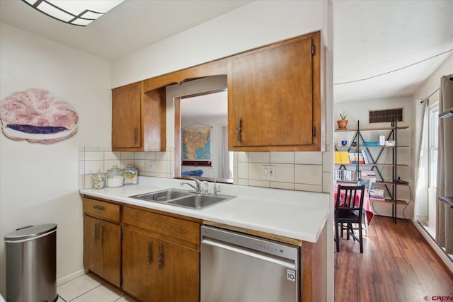 kitchen with a sink, brown cabinets, and stainless steel dishwasher