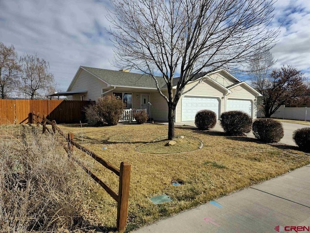 ranch-style home featuring an attached garage, driveway, and fence