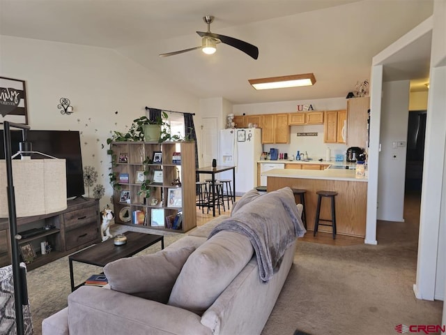 living area with carpet flooring, a ceiling fan, and vaulted ceiling