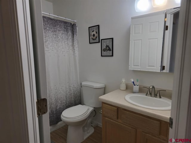 bathroom with vanity, a shower with curtain, toilet, and wood finished floors