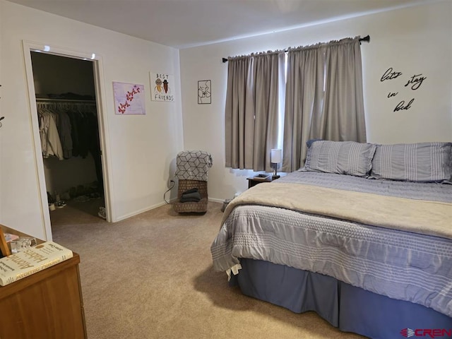 bedroom featuring a spacious closet, carpet, a closet, and baseboards