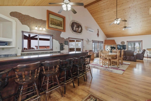 kitchen with wood finished floors, an AC wall unit, wood ceiling, and high vaulted ceiling