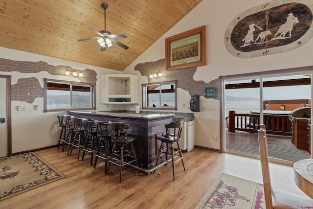 kitchen featuring baseboards, high vaulted ceiling, wooden ceiling, and light wood finished floors