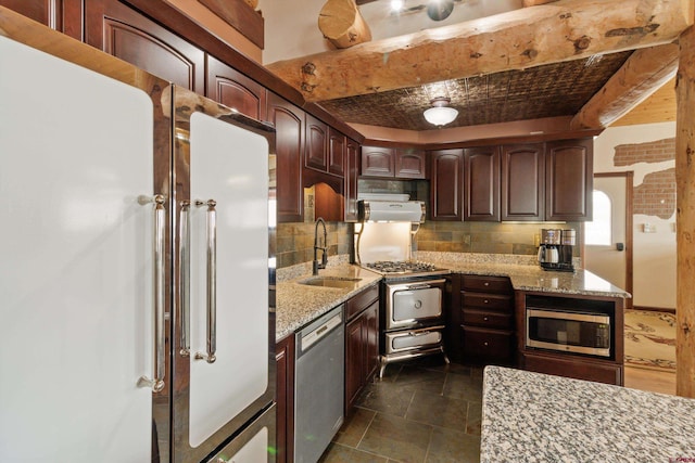 kitchen with light stone counters, decorative backsplash, stainless steel appliances, and a sink