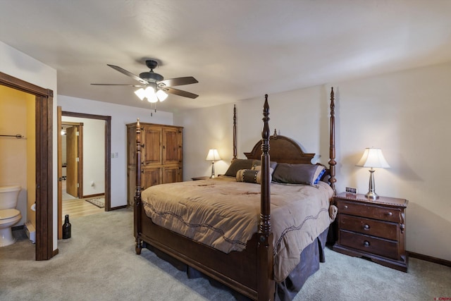 bedroom with ceiling fan, connected bathroom, baseboards, and light carpet