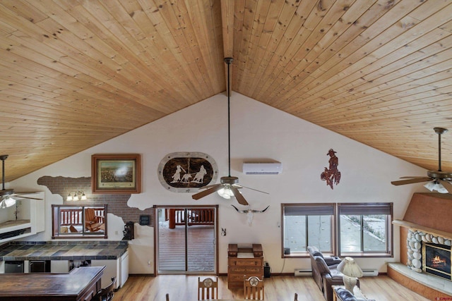 living area featuring light wood-type flooring, high vaulted ceiling, a stone fireplace, and ceiling fan