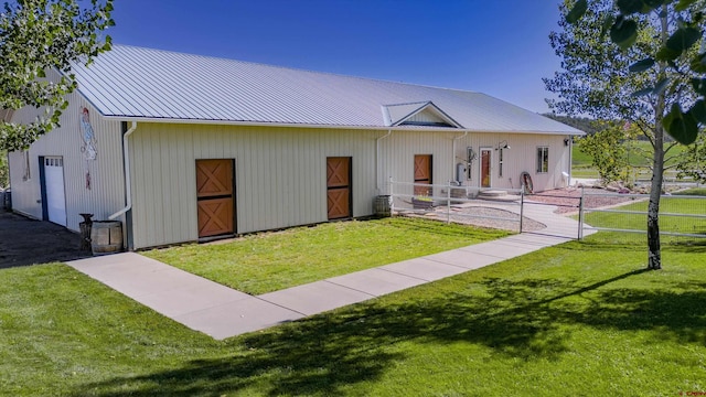 view of front of home with an outbuilding, an exterior structure, and metal roof