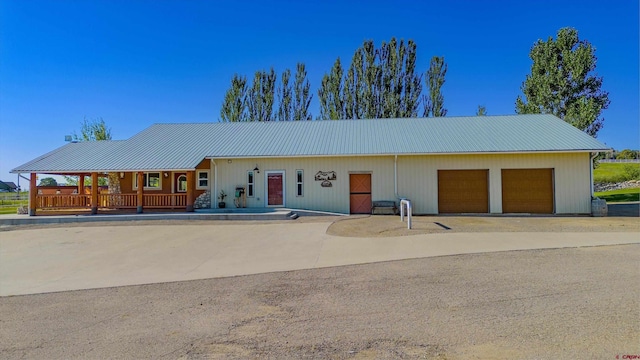 view of front of home with driveway and metal roof