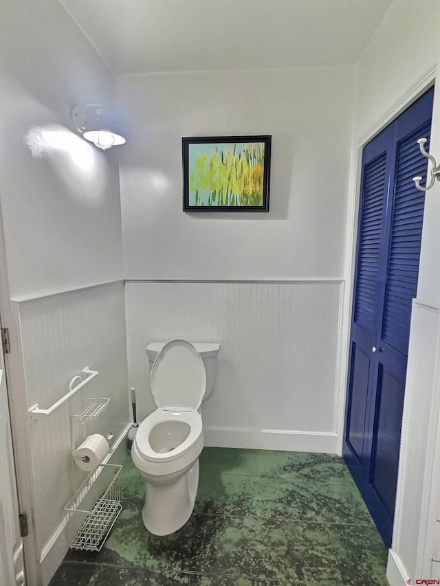 bathroom with wainscoting and toilet