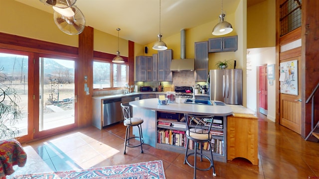 kitchen with a sink, tile patterned flooring, light countertops, stainless steel appliances, and wall chimney exhaust hood