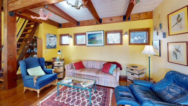 living room featuring beam ceiling, wood finished floors, and wooden ceiling