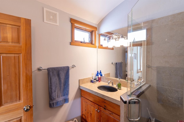 full bathroom featuring visible vents, tiled shower, lofted ceiling, and vanity