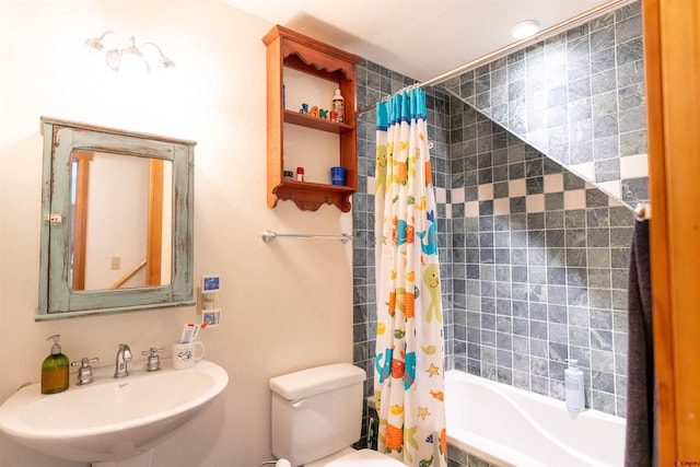 bathroom with toilet, tiled shower / bath, and a sink