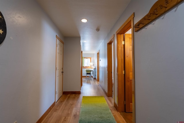 hallway with baseboards and light wood-type flooring