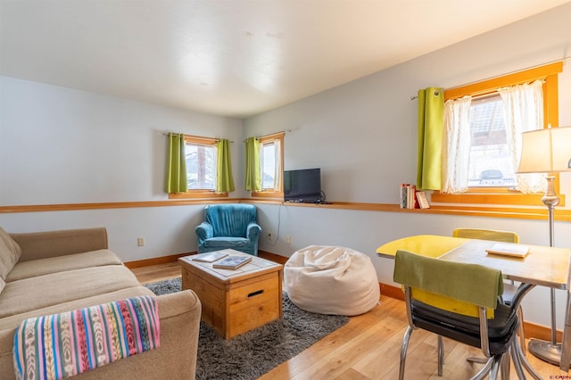 living area featuring wood finished floors, baseboards, and a wealth of natural light