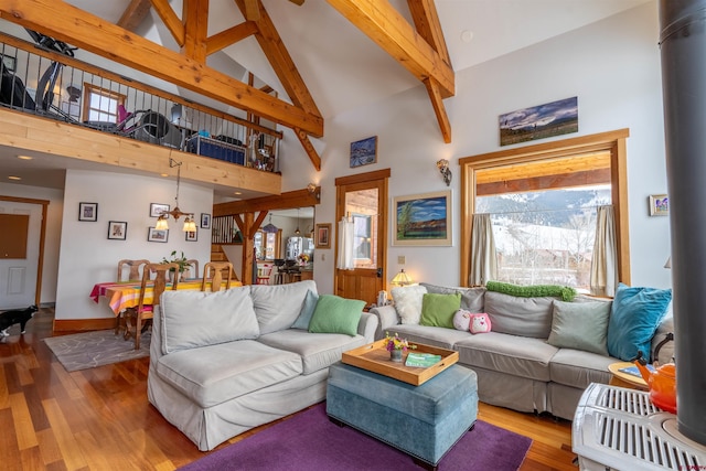 living room featuring a chandelier, beam ceiling, high vaulted ceiling, and wood finished floors