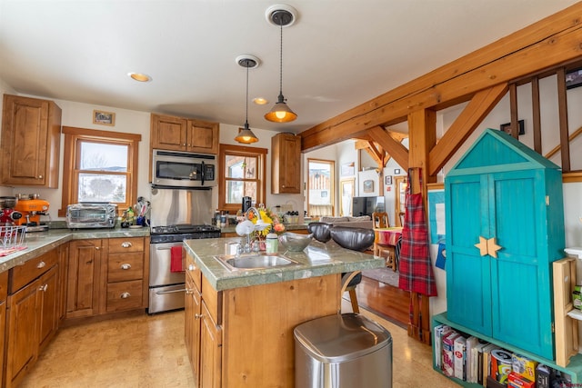 kitchen featuring brown cabinetry, light floors, a kitchen island, a sink, and stainless steel appliances