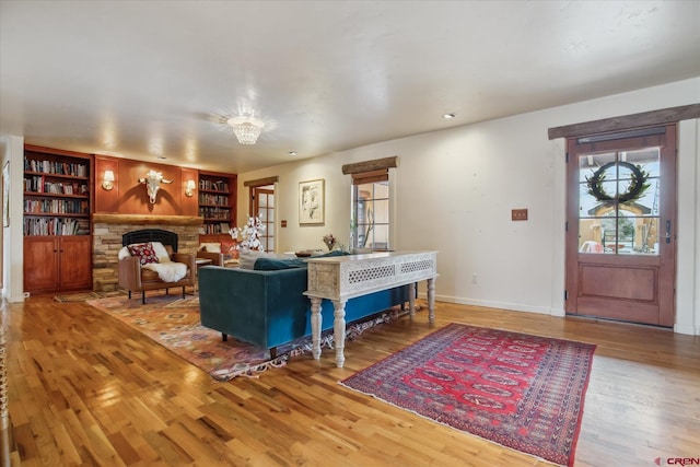 living room with a fireplace, wood finished floors, and baseboards