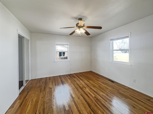 spare room featuring visible vents, a ceiling fan, and hardwood / wood-style floors