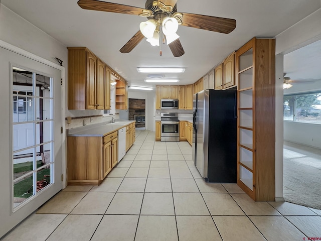 kitchen with light tile patterned floors, open shelves, stainless steel appliances, light countertops, and light carpet