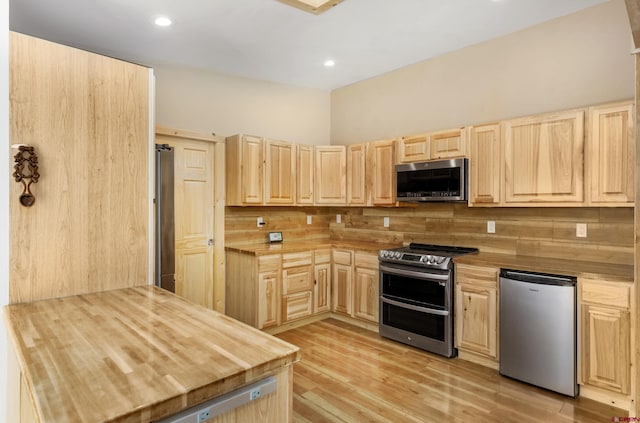 kitchen featuring wooden counters, light wood-type flooring, appliances with stainless steel finishes, and light brown cabinetry