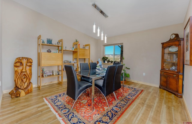 dining space with light wood-type flooring and baseboards