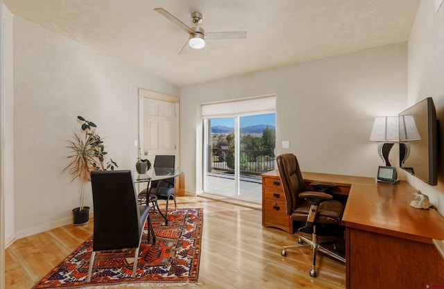 home office with a ceiling fan, wood finished floors, and baseboards