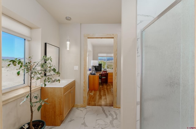 ensuite bathroom featuring vanity, ensuite bath, marble finish floor, and a shower stall