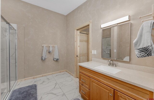 bathroom featuring a marble finish shower, baseboards, marble finish floor, and vanity