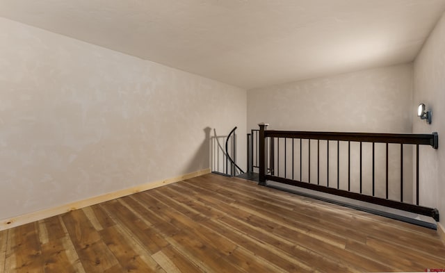 empty room with baseboards and wood-type flooring