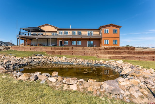 back of house with a small pond