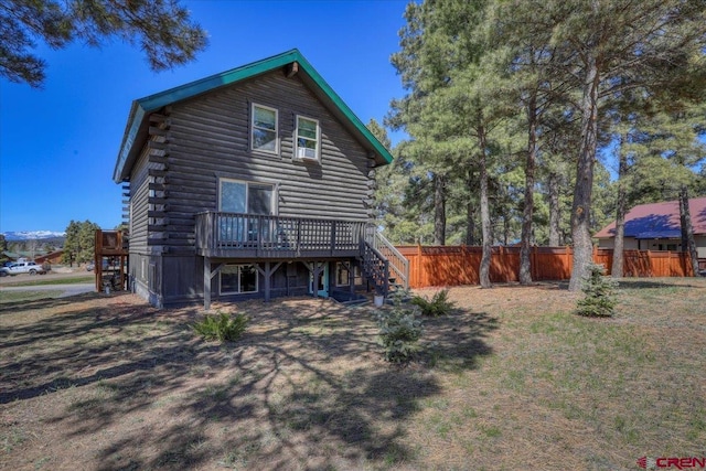 back of property with stairs, log exterior, fence, and a wooden deck