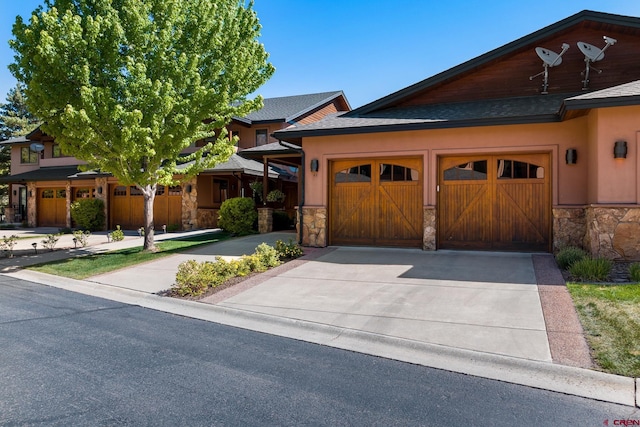 view of front facade with roof with shingles, an attached garage, stucco siding, concrete driveway, and stone siding