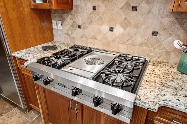 kitchen with tasteful backsplash, brown cabinets, and stainless steel gas stovetop