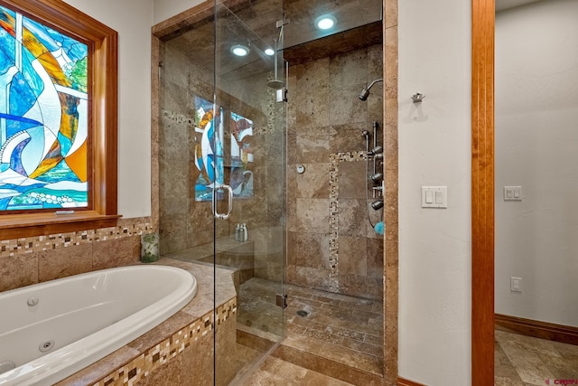 full bathroom featuring baseboards, a jetted tub, and a shower stall