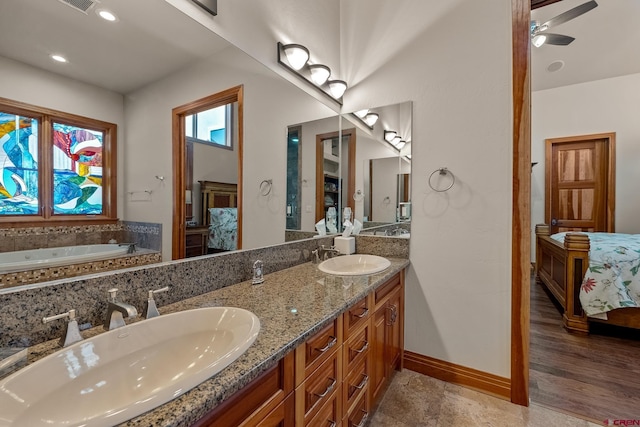 ensuite bathroom with double vanity, baseboards, ensuite bathroom, and a sink