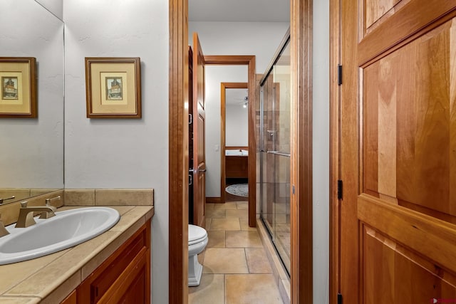 bathroom featuring vanity, a shower stall, and toilet