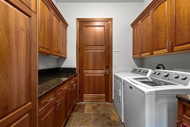 laundry area with independent washer and dryer, cabinet space, and stone tile floors