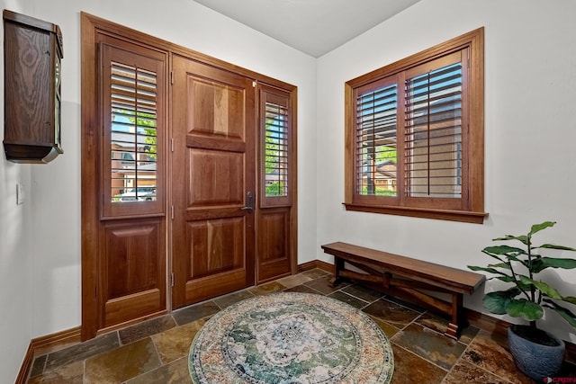 entrance foyer with stone tile floors and baseboards