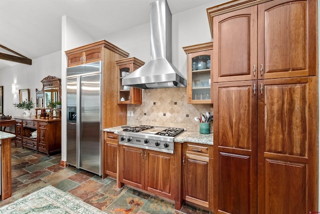 kitchen featuring stone finish floor, glass insert cabinets, appliances with stainless steel finishes, decorative backsplash, and extractor fan