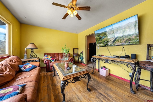 living room with wood finished floors and a ceiling fan