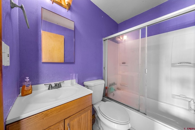 full bath with toilet, vanity, and bath / shower combo with glass door