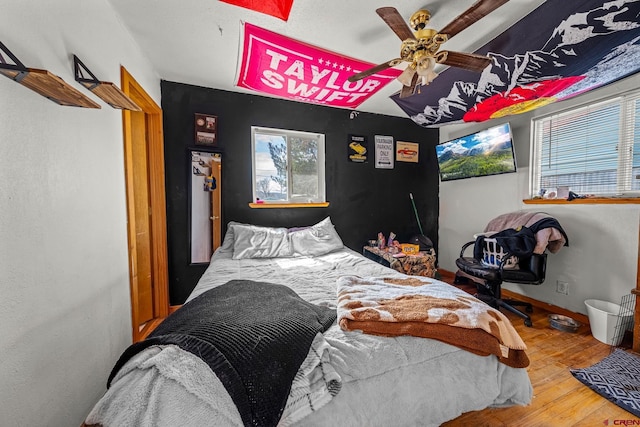 bedroom featuring a ceiling fan, wood finished floors, and baseboards