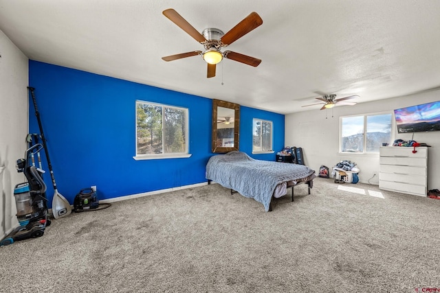 bedroom with carpet, a ceiling fan, and a textured ceiling